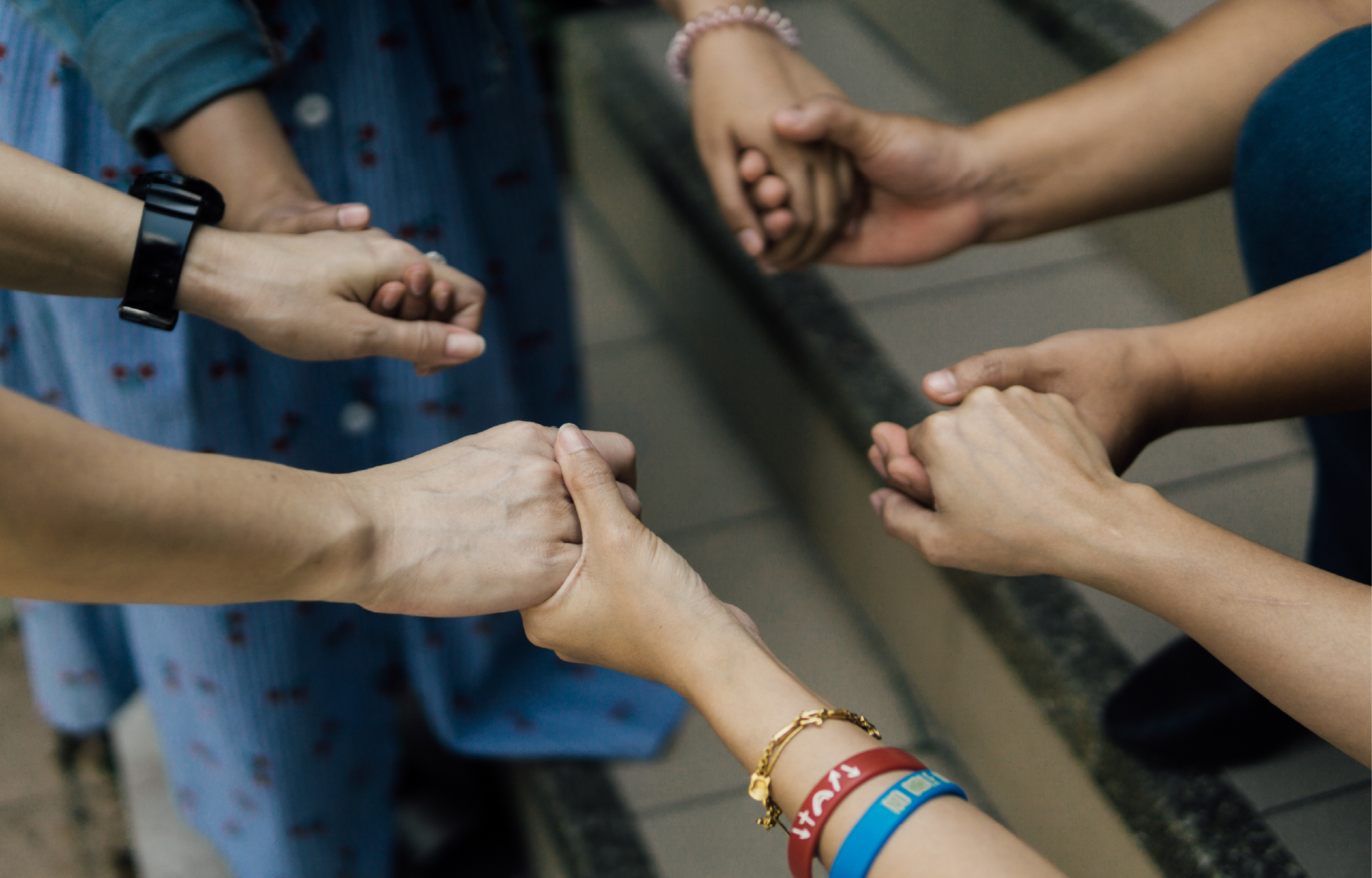 Four pairs of hands joined in a circle