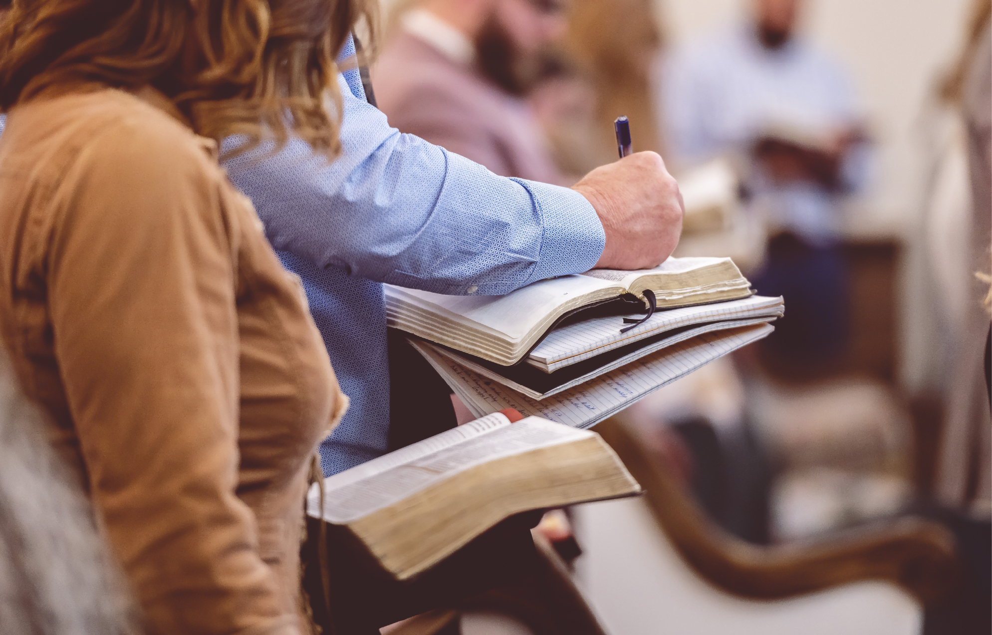 People with open Bibles standing in a chruch service